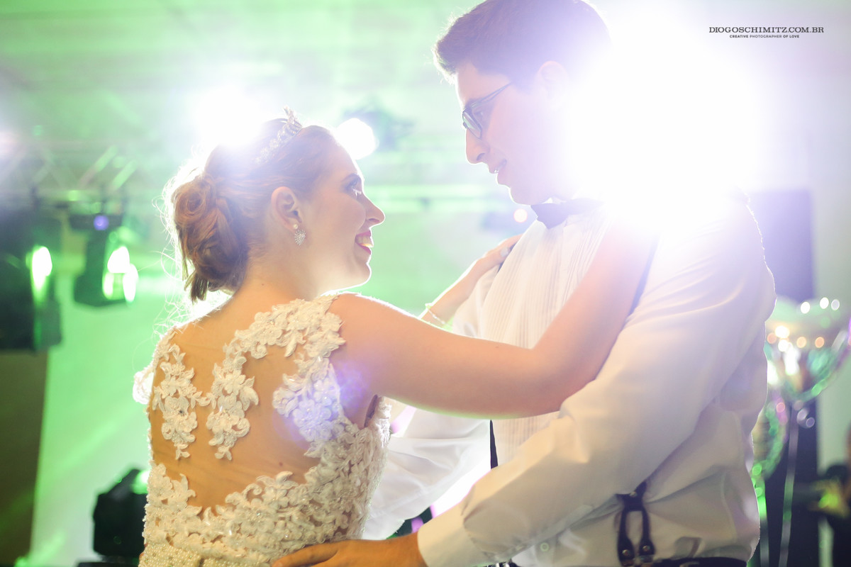 Os noivos dançam a valsa sorridentes.